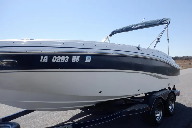 Slide: The Image of 2014 Hurricane SunDeck Sport 203 OB boat on trailer, side view, blue and white design. - 10