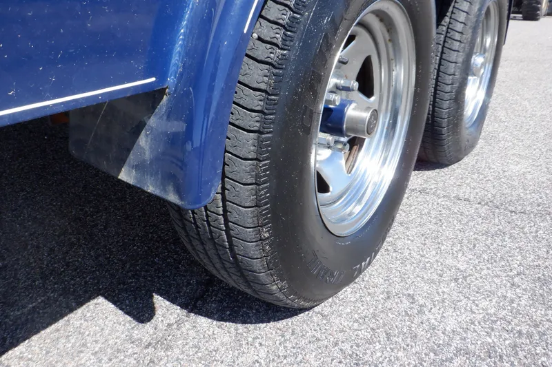 Slide: The Image of Close-up of 2014 Hurricane SunDeck Sport 203 OB trailer wheels on pavement. - 14