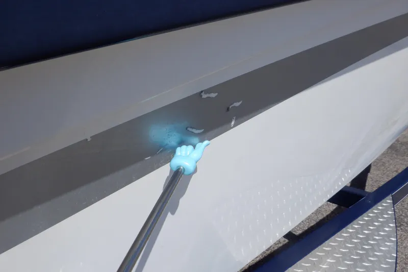 Slide: The Image of 2014 Hurricane SunDeck Sport 203 OB boat with hull scratches being inspected. - 15