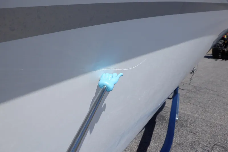 Slide: The Image of 2014 Hurricane SunDeck Sport 203 OB boat with hull damage and repair tool. - 16