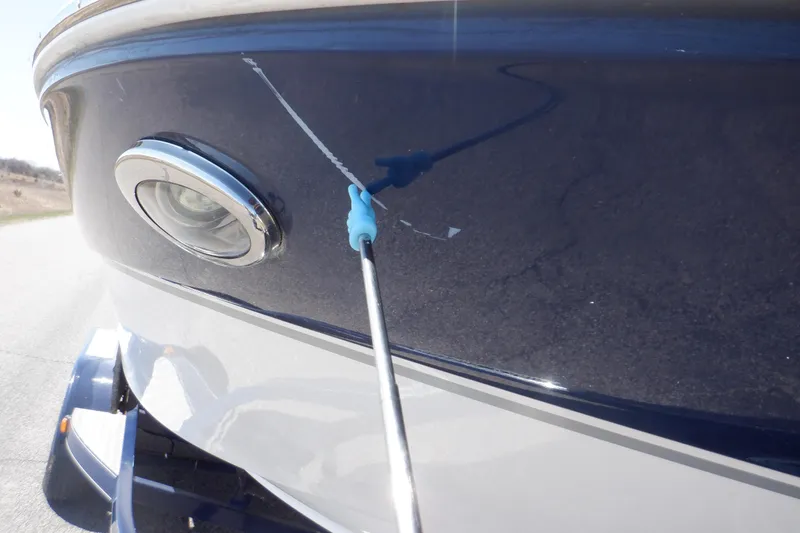 Slide: The Image of 2014 Hurricane SunDeck Sport 203 OB boat with a scratch on the blue hull. - 19