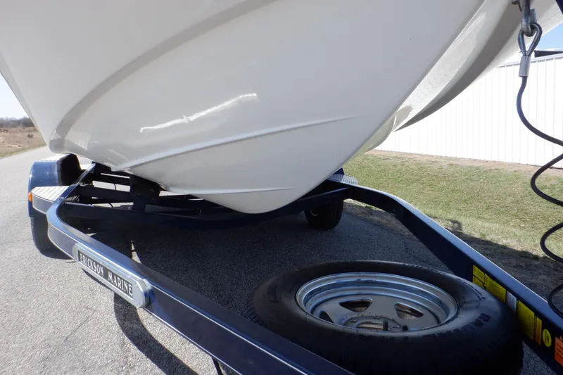 Slide: The Image of 2014 Hurricane SunDeck Sport 203 OB boat on trailer, close-up of hull and spare tire. - 21