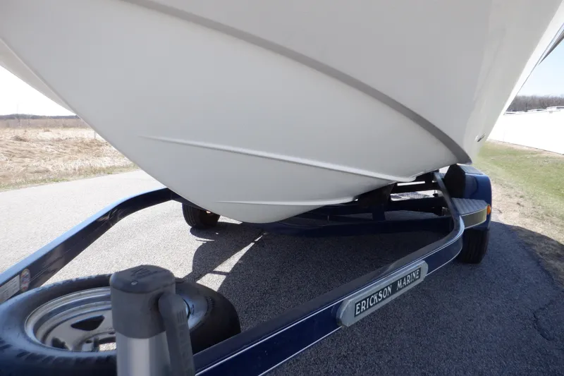 Slide: The Image of 2014 Hurricane SunDeck Sport 203 OB boat on trailer, close-up of hull and trailer details. - 24