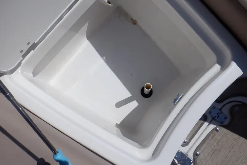Slide: The Image of 2014 Hurricane SunDeck Sport 203 OB boat storage compartment with drain plug. - 47