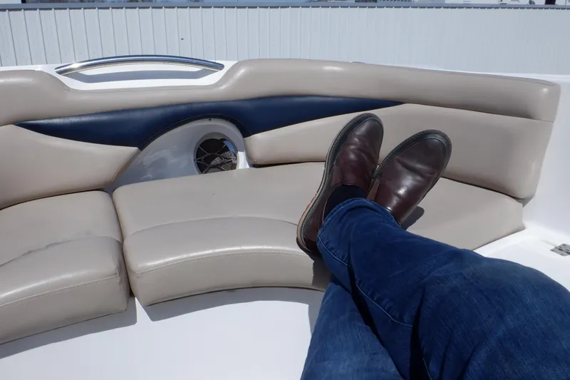 Slide: The Image of Person relaxing on a 2014 Hurricane SunDeck Sport 203 OB boat's cushioned seating. - 49