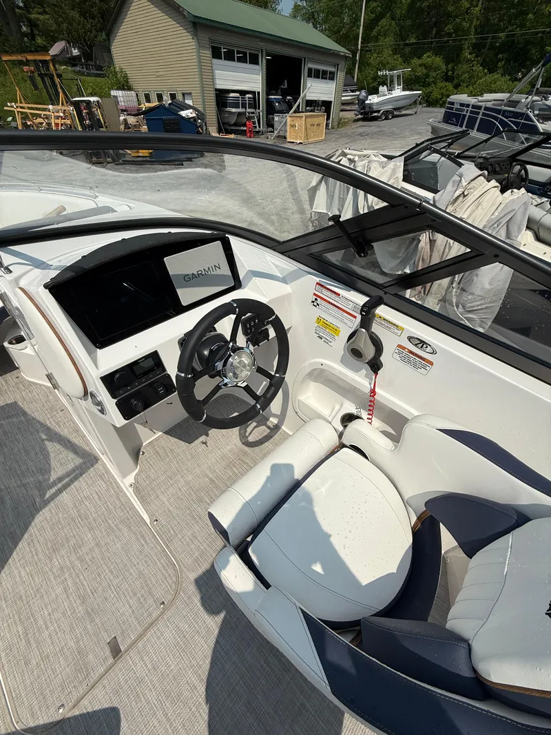 Slide: The Image of 2025 Stingray 211DC boat interior with steering wheel and dashboard. - 12