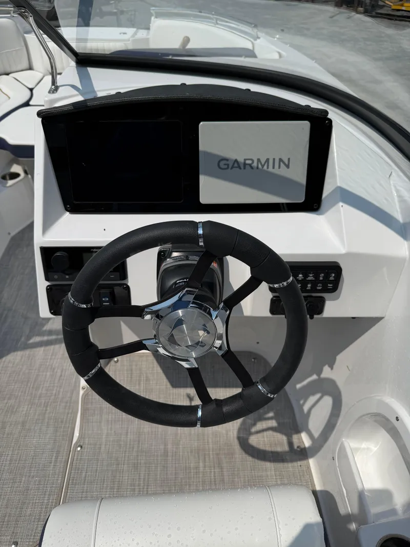 Slide: The Image of 2025 Stingray 211DC boat dashboard with Garmin navigation system and steering wheel. - 13