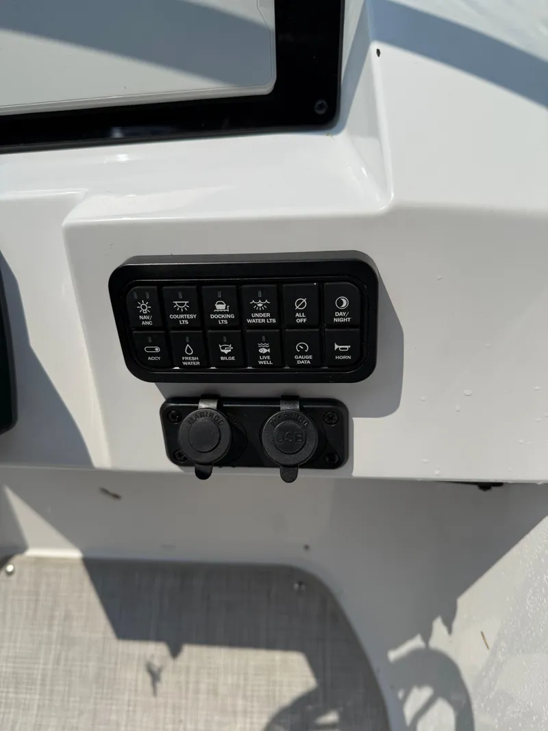 Slide: The Image of Control panel of 2025 Stingray 211DC boat with various switches and outlets. - 15