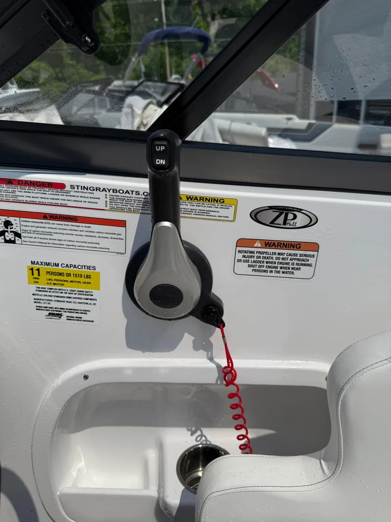 Slide: The Image of 2025 Stingray 211DC boat interior with control panel and warning labels. - 16