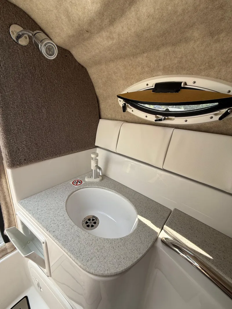 Slide: The Image of 2025 Stingray 211DC boat interior with sink and porthole window. - 20