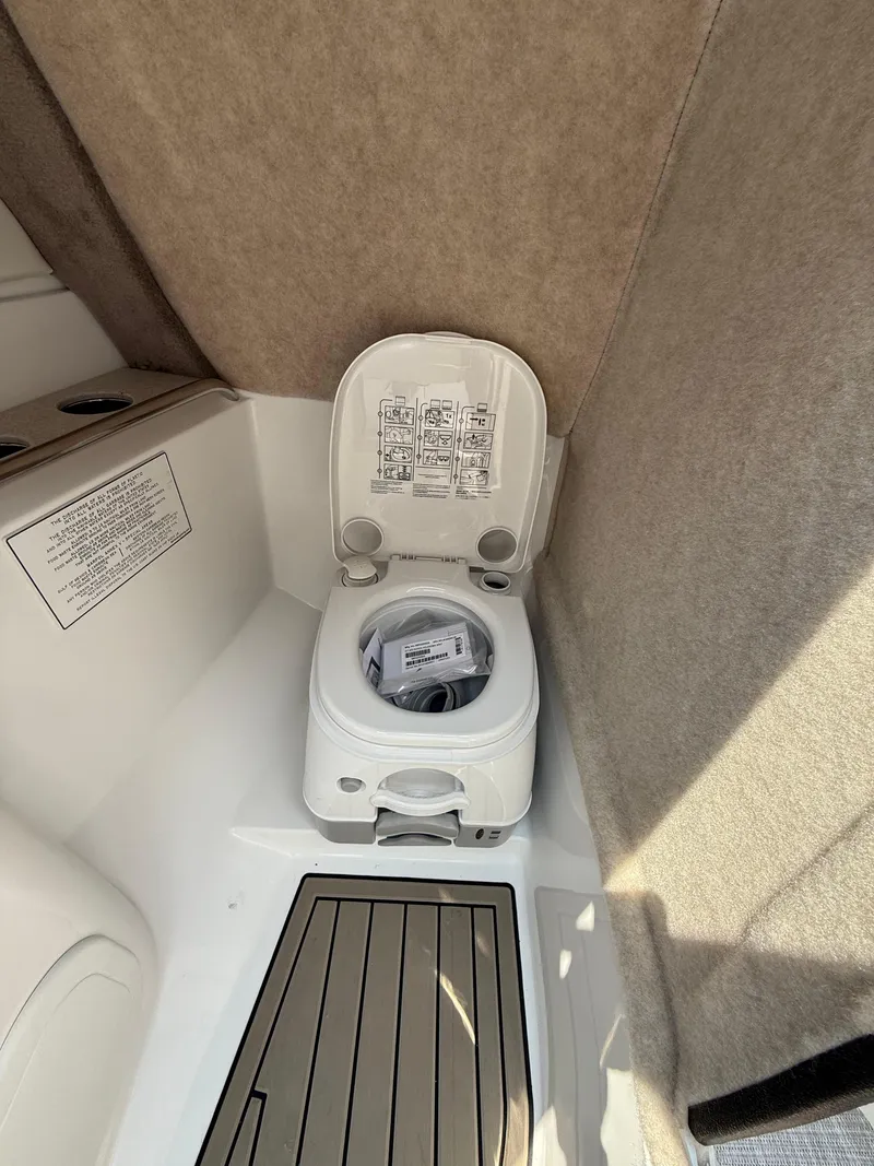 Slide: The Image of 2025 Stingray 211DC boat interior with compact marine toilet. - 21
