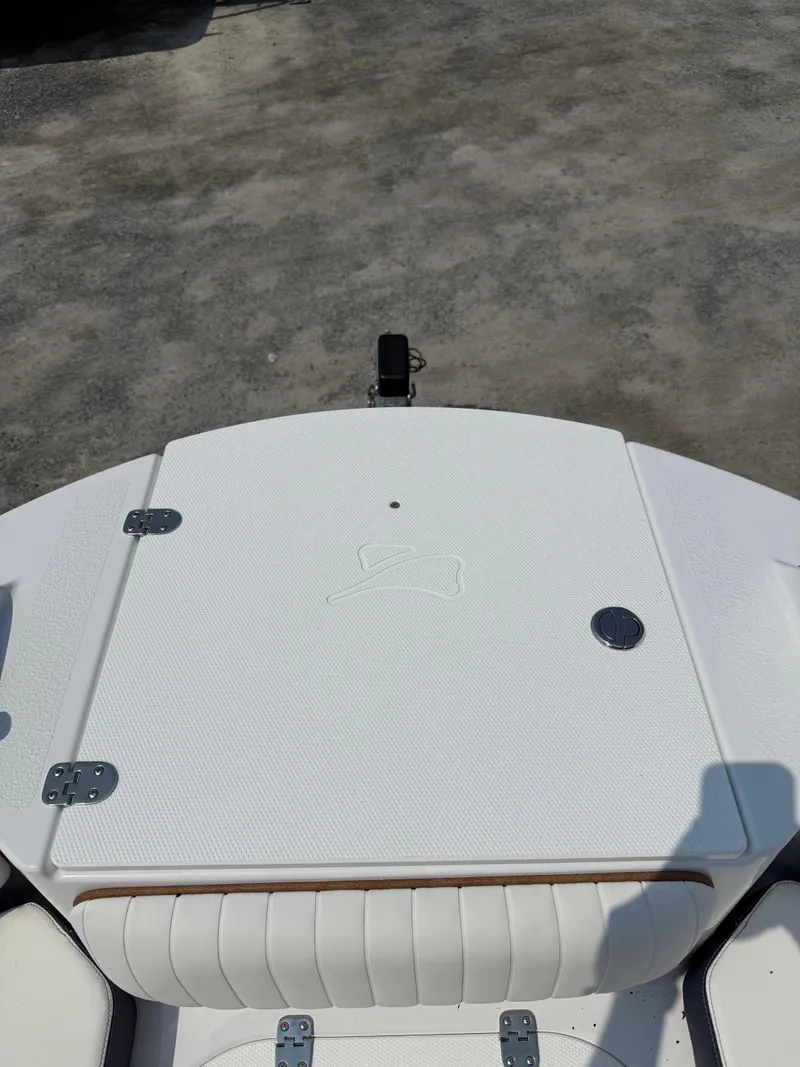 Slide: The Image of 2025 Stingray 211DC boat deck with white upholstery and storage compartment. - 27