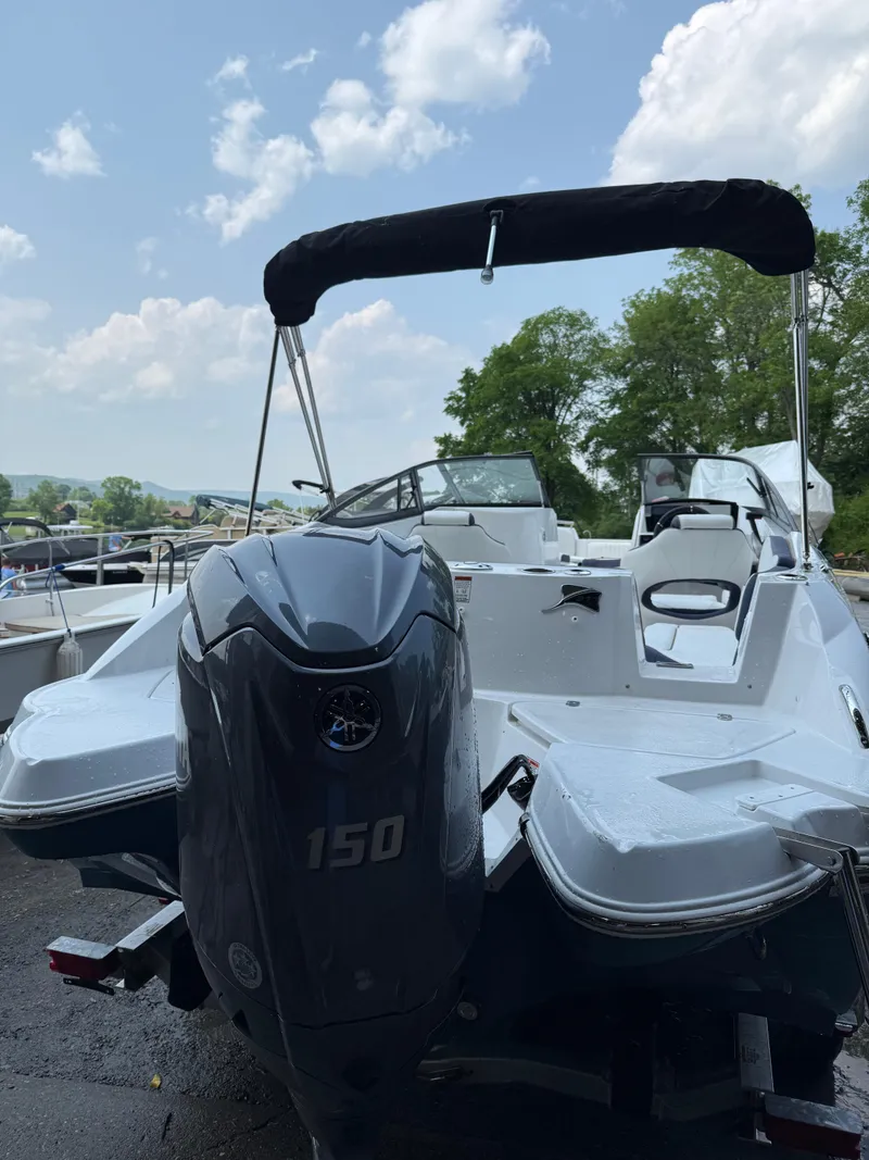 Slide: The Image of 2025 Stingray 211DC boat with 150 HP engine, docked under a clear sky. - 6