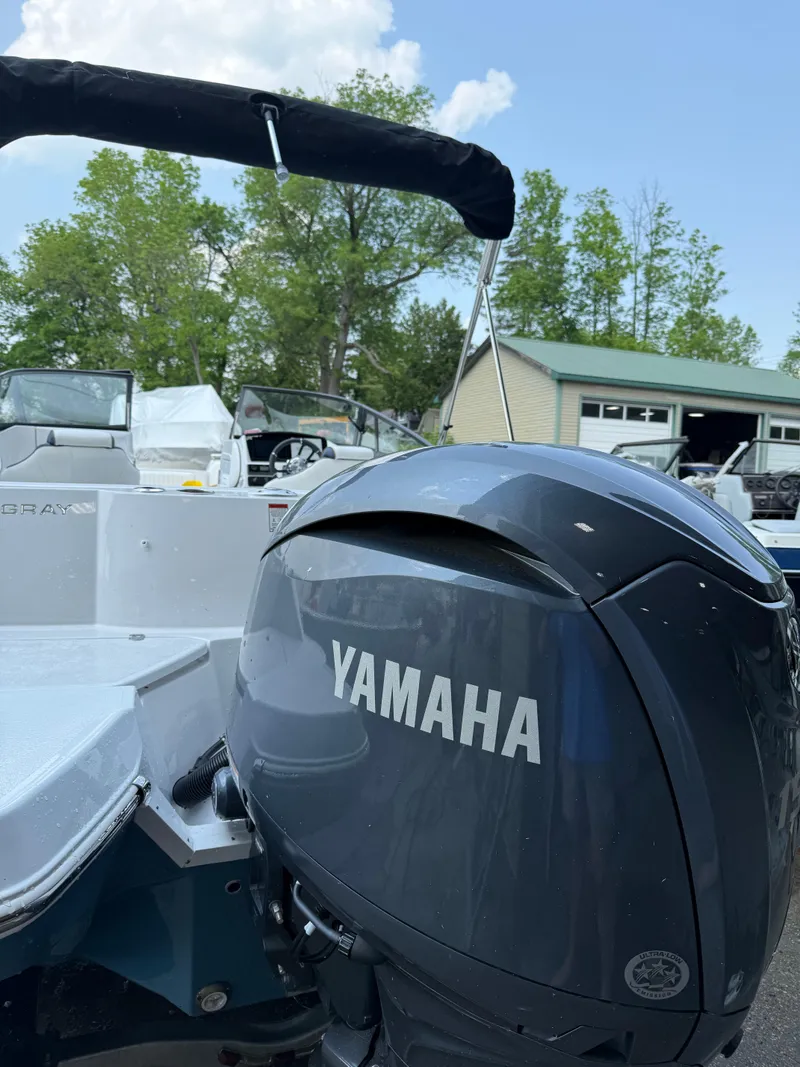 Slide: The Image of 2025 Stingray 211DC boat with Yamaha outboard motor, parked outdoors. - 7