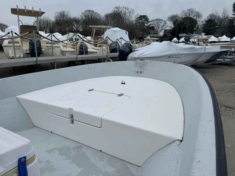 Slide: The Image of 2003 Maritime 1690 boat docked, surrounded by other covered boats in a marina. - 12