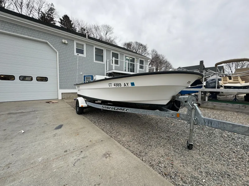 Slide: The Image of 2003 Maritime 1690 boat on trailer outside a garage. - 13