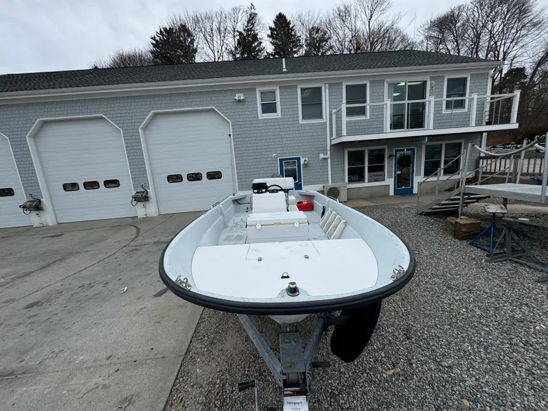 Slide: The Image of 2003 Maritime 1690 boat on trailer in front of a gray building with garage doors. - 14