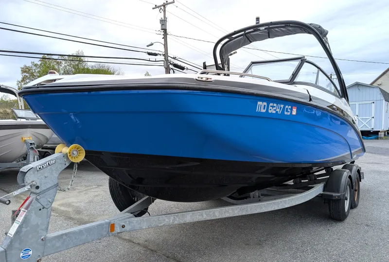 Slide: The Image of 2017 Yamaha Boats AR210 on trailer, blue hull, parked outdoors. - 9