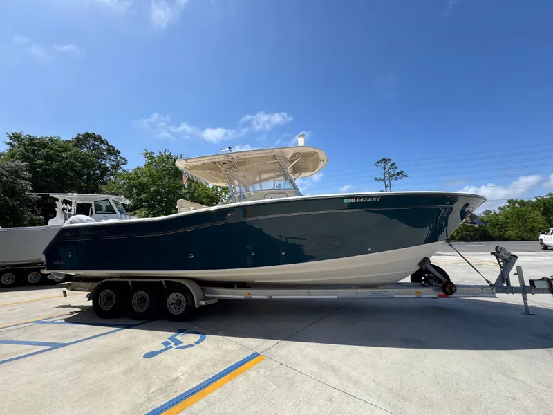 Slide: The Image of 2014 Grady-White Canyon 336 boat on trailer, parked outdoors under clear blue sky. - 13