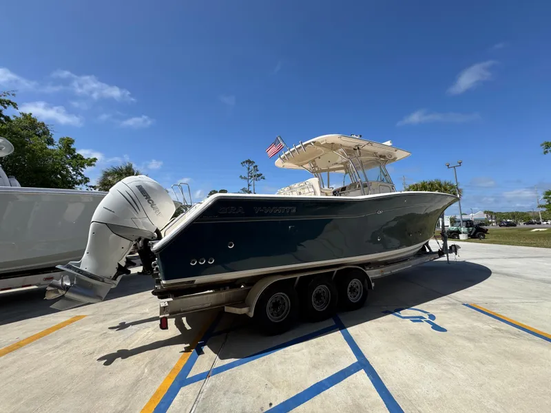 Slide: The Image of 2014 Grady-White Canyon 336 boat on trailer, parked outdoors under clear blue sky. - 16