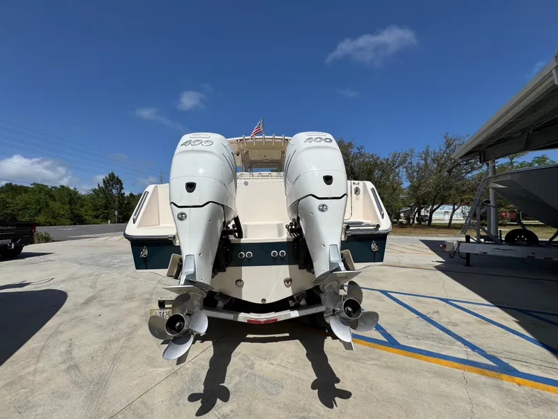 Slide: The Image of 2014 Grady-White Canyon 336 boat with dual outboard engines, parked outdoors. - 21