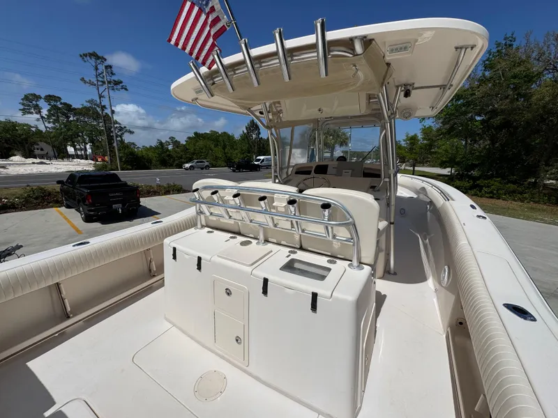 Slide: The Image of 2014 Grady-White Canyon 336 boat with T-top and American flag, parked outdoors. - 43