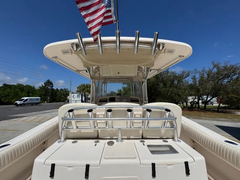 Slide: The Image of 2014 Grady-White Canyon 336 boat with American flag, docked under clear blue sky. - 45