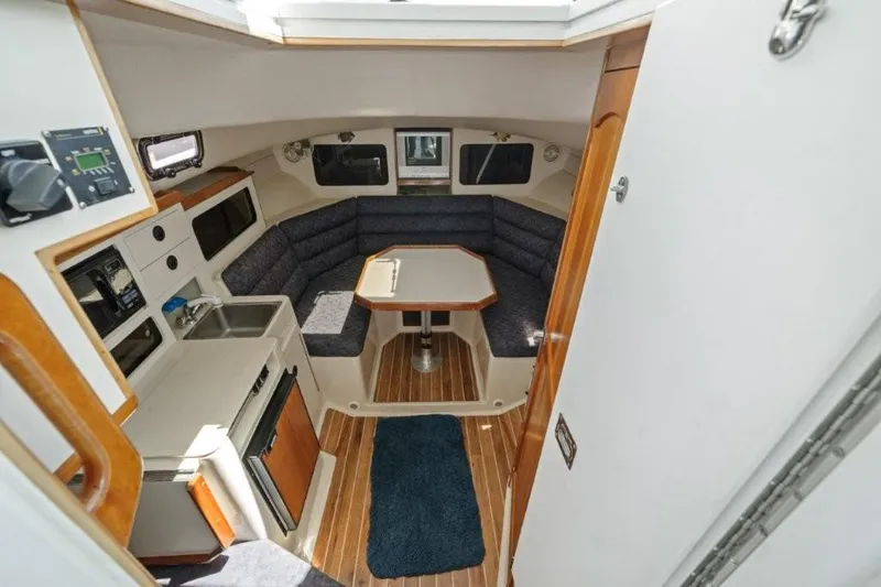 Slide: The Image of 2007 Albin 28 Tournament Express cabin interior with seating, table, and kitchenette. - 15