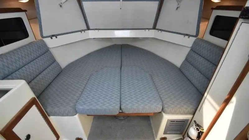 Slide: The Image of 2007 Albin 28 Tournament Express cabin interior with cushioned seating and storage. - 18