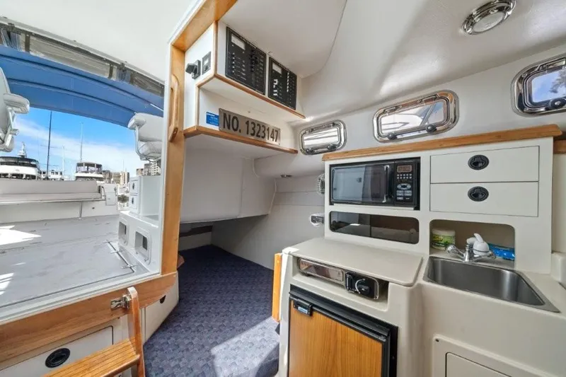 Slide: The Image of 2007 Albin 28 Tournament Express interior with kitchenette, microwave, and sink. - 19