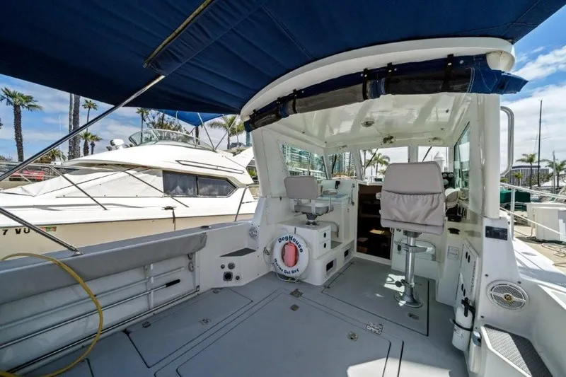 Slide: The Image of 2007 Albin 28 Tournament Express boat interior with seating and canopy, docked at marina. - 8