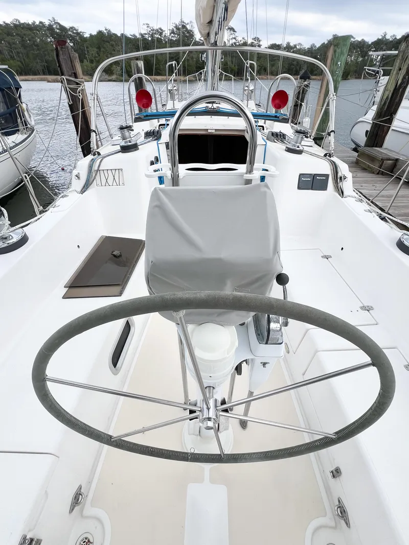 Slide: The Image of Cockpit of 1998 Saga 43 sailboat with steering wheel and marina background. - 12