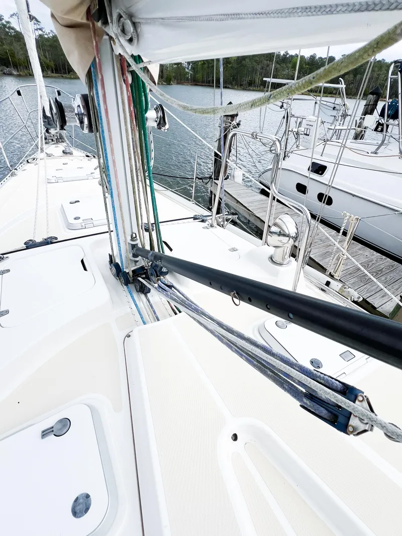 Slide: The Image of 1998 Saga 43 sailboat deck with rigging and docked boats in background. - 22
