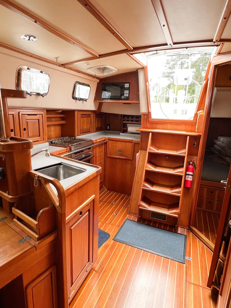 Slide: The Image of Interior of 1998 Saga 43 sailboat with wooden cabinetry and modern kitchen amenities. - 27