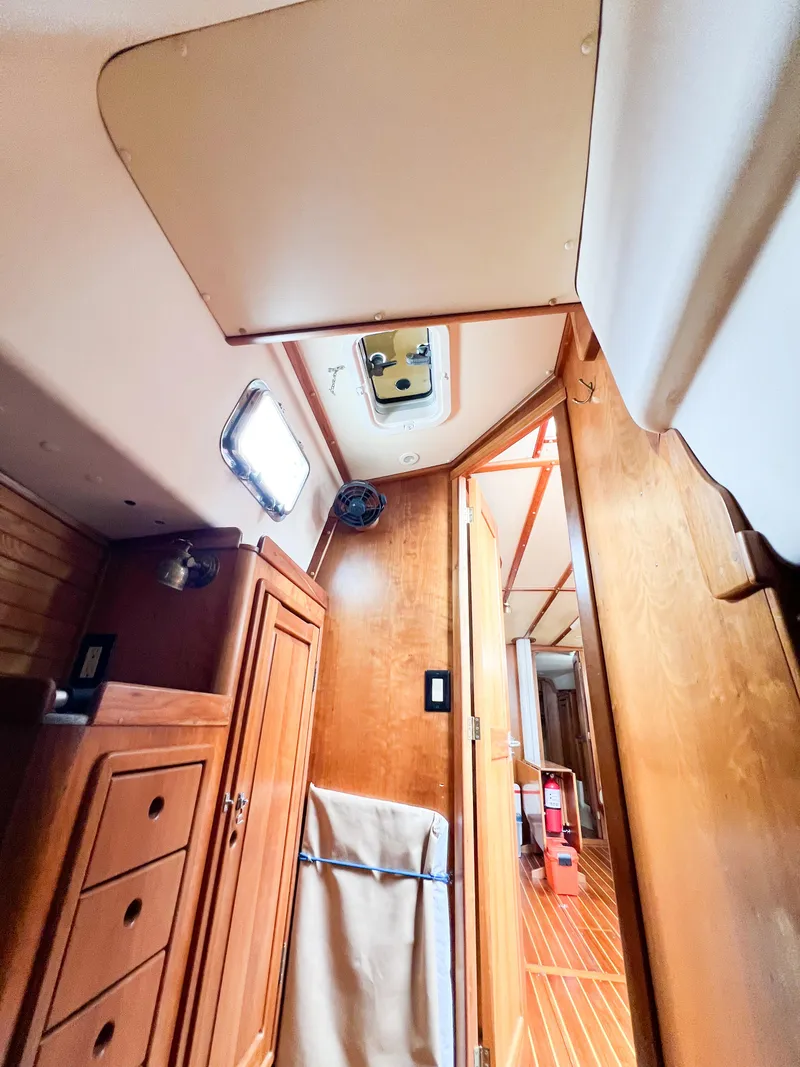 Slide: The Image of Interior of a 1998 Saga 43 sailboat, featuring wooden cabinetry and a skylight. - 39