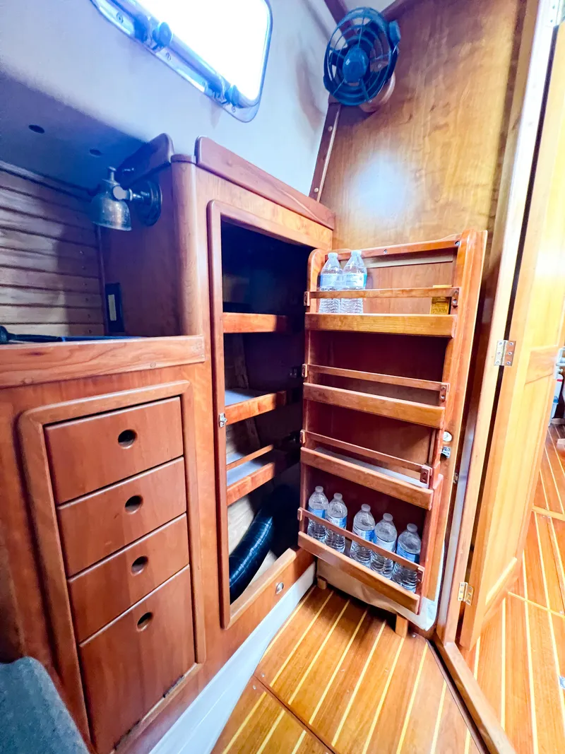 Slide: The Image of Wooden interior of 1998 Saga 43 yacht with storage shelves and water bottles. - 40