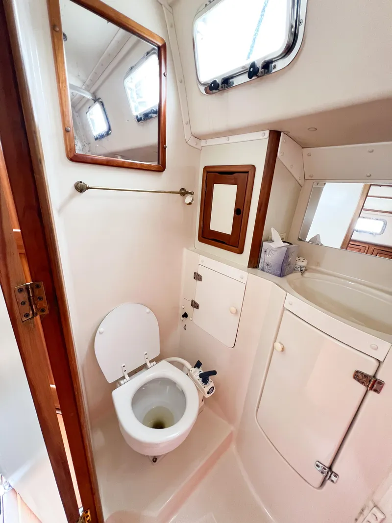Slide: The Image of Saga 43 yacht bathroom, 1998 model, featuring toilet, mirror, and storage cabinets. - 42