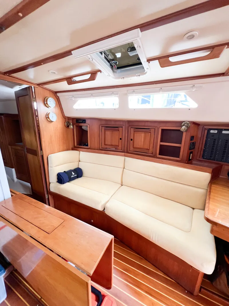 Slide: The Image of Interior of 1998 Saga 43 sailboat with beige seating and wooden cabinetry. - 45