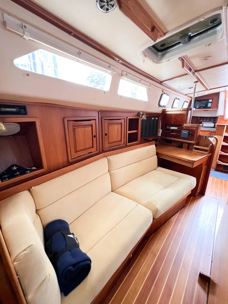 Slide: The Image of Interior of 1998 Saga 43 sailboat with wooden cabinetry and beige seating. - 48