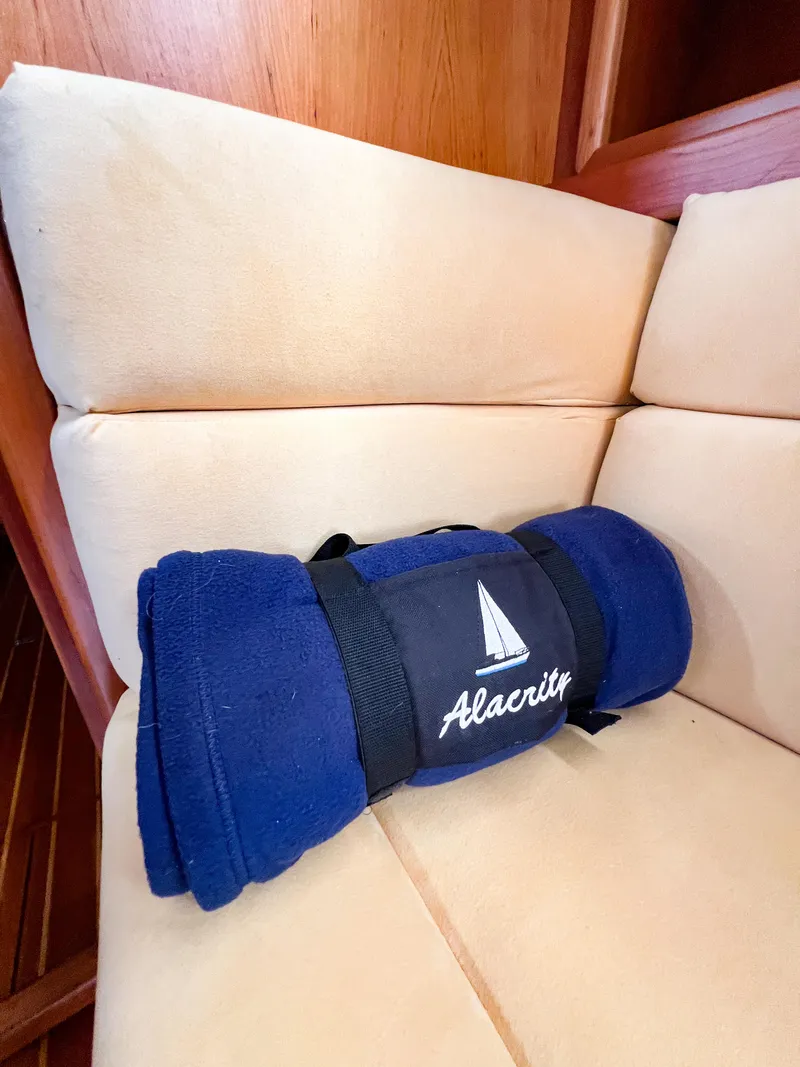 Slide: The Image of Blue blanket with "Alacrity" logo on beige boat seating, Saga 43, 1998 model. - 49