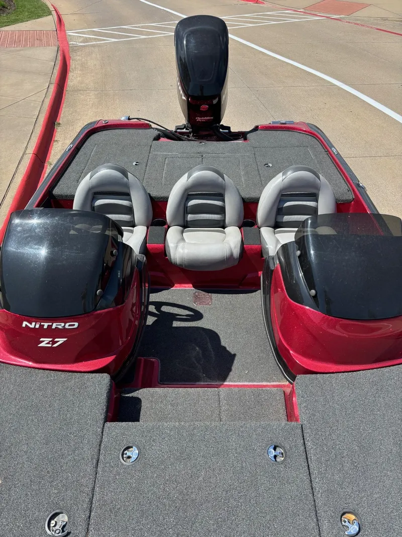 Slide: The Image of 2012 Nitro Z7 boat with red and gray seating, parked on a concrete surface. - 6