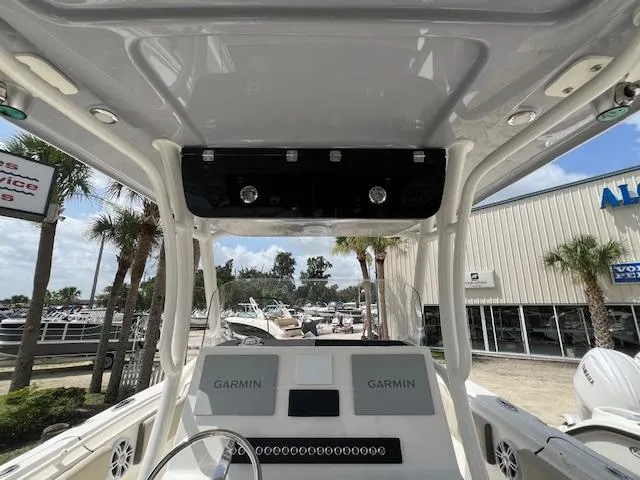 Slide: The Image of 2025 Key West 263 FS boat dashboard with dual Garmin displays, outdoor dealership setting. - 7