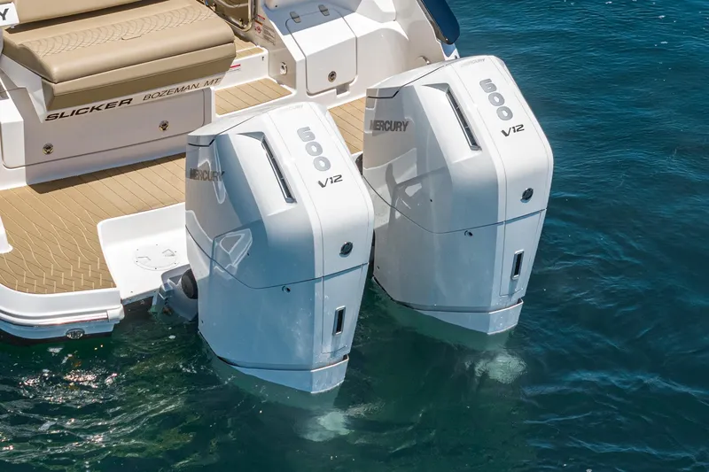Slide: The Image of Twin Mercury V12 engines on a 2023 Sea Ray Sundancer 370 OB in water. - 12