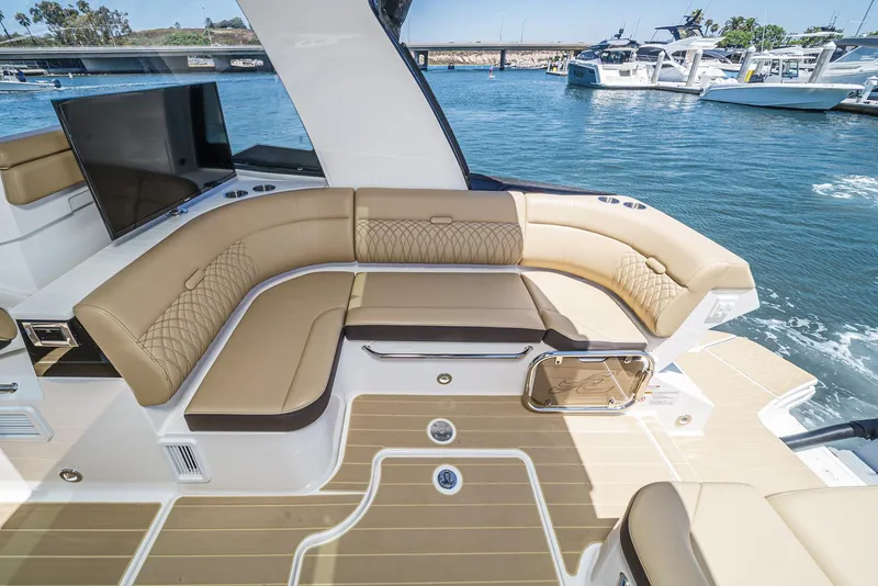 Slide: The Image of 2023 Sea Ray Sundancer 370 OB boat interior with luxurious seating and scenic marina view. - 17
