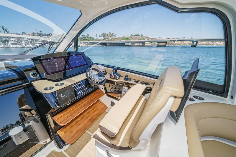 Slide: The Image of 2023 Sea Ray Sundancer 370 OB helm with modern controls and waterfront view. - 22