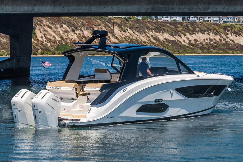 Slide: The Image of 2023 Sea Ray Sundancer 370 OB cruising under a bridge on a sunny day. - 9