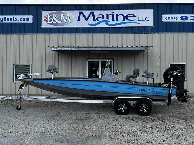Slide: The Image of 2025 Xpress H22 Bay boat on trailer outside L&M Marine LLC building. - 0