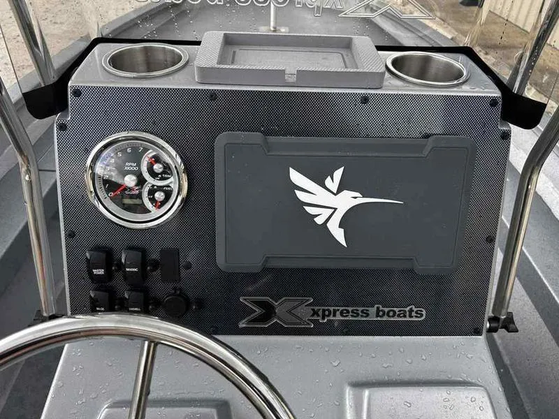 Slide: The Image of 2025 Xpress H22 Bay boat dashboard with logo and gauges. - 11