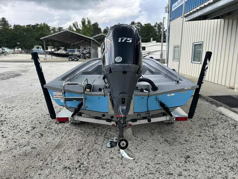Slide: The Image of 2025 Xpress H22 Bay boat with 175 HP engine, parked on gravel. - 2