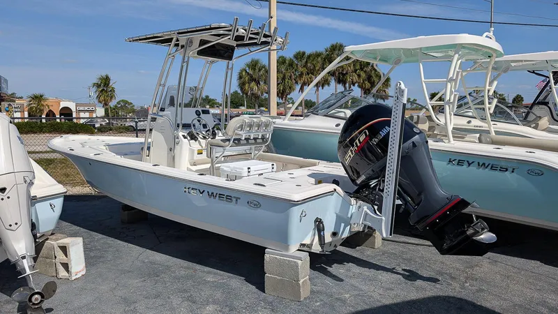 Slide: The Image of 2025 Key West 210 Bay Reef boat displayed on blocks at a dealership. - 1